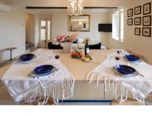 a table with blue plates and wine glasses on it at Casa Collodi Castello in Collodi