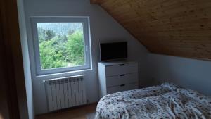 a bedroom with a bed and a window at House of Laura in Băile Tuşnad