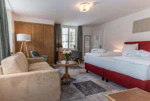 Habitación de hotel con cama y sofá en De France by Thermalhotels, en Leukerbad