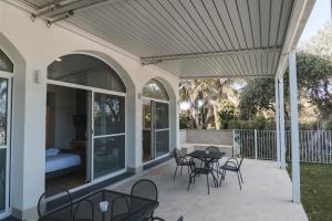 a patio with a table and chairs and a bed at Sicilia's Art Hotel & Spa in Acitrezza