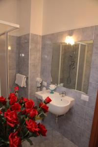 a bathroom with a sink and red roses at B&B Rinascente in Paola