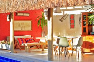un patio con mesa, sillas y una pared roja en Vila Querência - Trancoso, en Trancoso