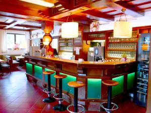 eine Bar in einem Restaurant mit Hockern in der Unterkunft HartlWirt Gasthof-Hotel in Salzburg