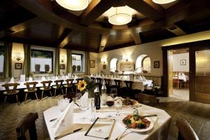 a dining room with white tables and chairs at HartlWirt Gasthof-Hotel in Salzburg
