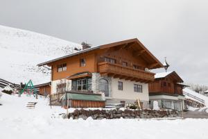 a large wooden house in the snow at Haus Bucher in Wagrain