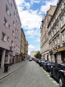 a cobblestone street in a city with parked cars at Centrum Apartament Old Town in Świdnica