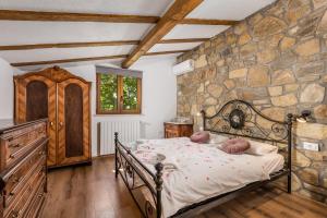 a bedroom with a bed in a stone wall at Rona Apartment & Rooms Mea Vista in Buzet