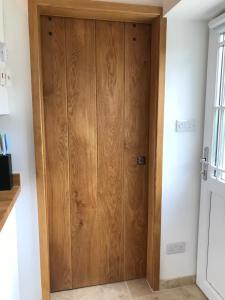 una puerta de madera en una habitación en The Studio @ The Old Vicarage en Pendeen