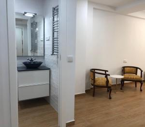a bathroom with a sink and a table and chairs at Brand NEW Studio Centro Histórico, La Latina - Plaza Mayor in Madrid