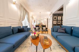 una sala de estar con sofás azules y una mesa. en Bliss Lisbon Apartments - Avenidas, en Lisboa