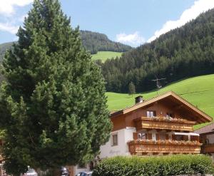 a house with a balcony and a tree at Haus Pipperger in Cadipietra