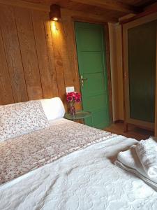1 dormitorio con 1 cama grande y puerta verde en Casa Rural La Bodega, en Aldeadávila de la Ribera