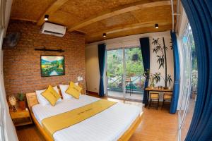 a bedroom with a large bed and a brick wall at An Thái Homestay and Bar in Ninh Binh