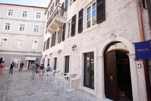 a street with white tables and chairs on a building at Boutique Hotel Astoria in Kotor