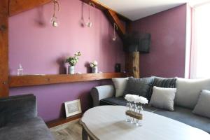 sala de estar con paredes de color púrpura y mesa en Colmar City Center - Apartment Duplex MARIGNY - BookingAlsace, en Colmar