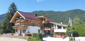 duży drewniany dom z balkonami na górze w obiekcie Aparthotel Buchauer-Tirol w mieście Thiersee