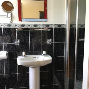 a bathroom with a white sink and a mirror at Ballyvaughan Lodge Guesthouse in Ballyvaughan