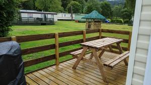 a wooden deck with a picnic table and a gazebo at Lyndhurst Corner in Dunoon