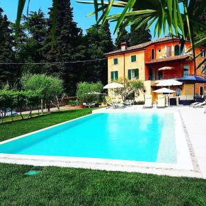 a large blue swimming pool in front of a house at Residenza Eden in Colà di Lazise