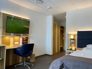 a hotel room with a bed and a tv on a wall at Hotel Wieting in Oldenburg