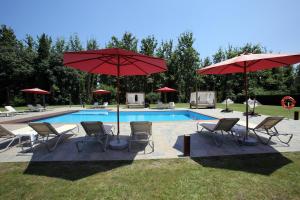 a pool with chairs and umbrellas next to at Mas la Casassa in Sant Gregori