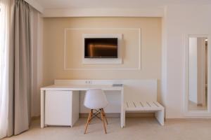 a room with a white wall and a white chair at Gran Hotel Peñiscola in Peniscola