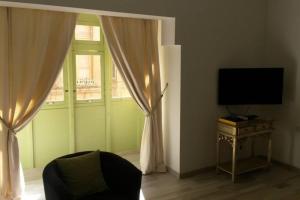 ein Wohnzimmer mit einem Fenster und einem TV in der Unterkunft St Nicholas in Valletta