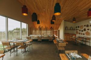 a restaurant with wooden ceilings and tables and chairs at Santa Barbara Eco-Beach Resort in Ribeira Grande