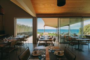 a restaurant with tables and chairs and a view of the ocean at Santa Barbara Eco-Beach Resort in Ribeira Grande