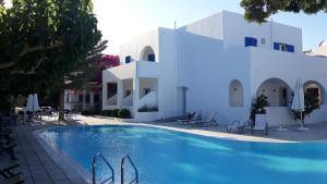 a swimming pool in front of a white building at Hippocampus Hotel in Kamari