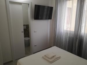 Schlafzimmer mit einem Bett und einem TV an der Wand in der Unterkunft SMART Rooms Pistoia in Pistoia