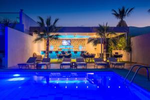 a villa with a swimming pool at night at Primavera Beach Hotel Studios & Apartments in Malia