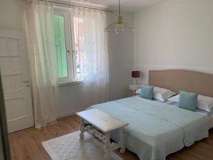 ein weißes Schlafzimmer mit einem Bett und einem Fenster in der Unterkunft Al viale - a Negrar nel cuore della Valpolicella in Negrar