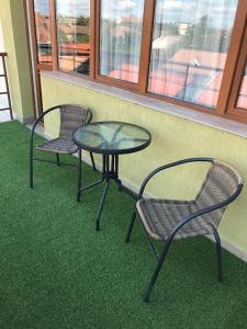 duas cadeiras e uma mesa e uma mesa e cadeiras em SOLE Apartment 2 em Satu Mare