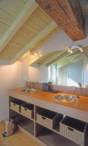 a bathroom with two sinks and a large mirror at Gite Coquelicots in Sanvensa