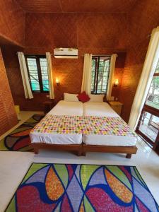 a bedroom with a large bed with a colorful blanket at Coconut Garden in Cherai Beach