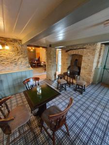 ウェイマスにあるThe Lugger Innのテーブルと椅子、暖炉が備わる客室です。