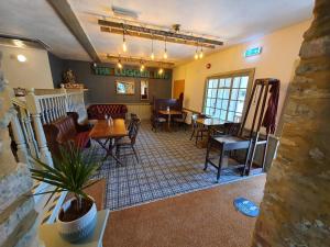 a living room with tables and chairs in a building at The Lugger Inn in Weymouth