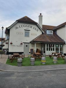 a large white building with a bunch of wooden chairs around it at The Lugger Inn in Weymouth