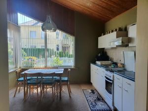 een keuken met een tafel en stoelen en een raam bij Gražinos ir Vinco namai in Palanga