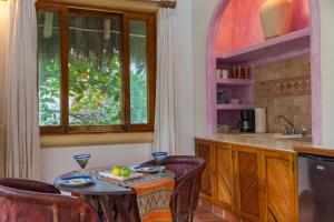 
a kitchen with a table, chairs, and a window at Hotel Vogue in Sayulita
