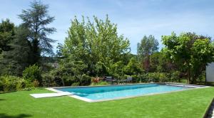 a swimming pool in a yard with green grass at Chambre BEAUSEJOUR in Brive-la-Gaillarde