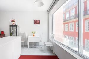 Apartamento con paredes y ventanas blancas y alfombra roja en Miguel Bombarda - Porto Houses & Suites, en Oporto