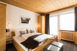 a bedroom with a bed and a chair at Hotel Hafele in Kaunertal