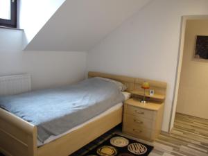 a small bedroom with a bed and a night stand at Fewo Ruhrblick com in Wickede (Ruhr)