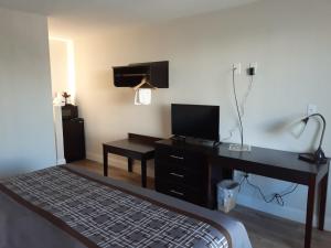 a bedroom with a desk and a bed with a television at Travelodge by Wyndham Virginia Beach Bay Beach in Virginia Beach