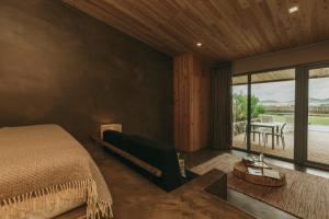 a bedroom with a bed and a large window at Santa Barbara Eco-Beach Resort in Ribeira Grande