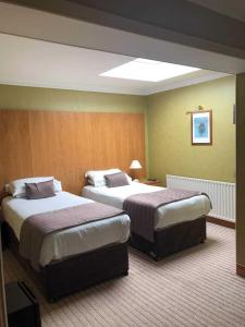 a hotel room with two beds in a room at Royal Court Hotel in Portrush