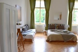 une chambre avec deux lits et un canapé dans l'établissement Wellness apartments Florenc, à Prague