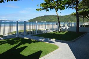 valla blanca con vistas a la playa en Belíssima Casa - Pé na areia - Bombinhas - Canto Grande, en Bombinhas